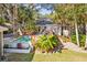 A spacious backyard with a pool, lounge chairs, green grass, tropical foliage and lush landscaping at 248 Forest Trail, Isle of Palms, SC 29451