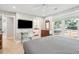 Bedroom with television, ensuite bathroom, desk, and a large window with tree views at 248 Forest Trail, Isle of Palms, SC 29451