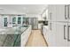 Bright, open kitchen features an island with green marble countertop, stainless appliances, and white cabinetry at 248 Forest Trail, Isle of Palms, SC 29451