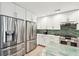 Modern kitchen features stainless steel appliances, white cabinets, and an island with marble countertop at 248 Forest Trail, Isle of Palms, SC 29451