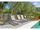 Relaxing poolside deck with lounge chairs, green foliage and shady trees for ultimate outdoor comfort at 248 Forest Trail, Isle of Palms, SC 29451