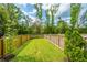 Well-maintained backyard featuring a lush green lawn, a wood fence, and mature trees in a sunny day at 249 Oak View Way, Summerville, SC 29483