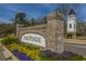 Welcoming entrance to The Ponds community featuring a brick sign, colorful flowers, and a charming white tower at 249 Oak View Way, Summerville, SC 29483