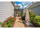 Outdoor patio with a black pergola, seating, barbecue grill, and manicured garden with blooming roses at 249 Oak View Way, Summerville, SC 29483