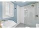 Modern bathroom with walk-in glass shower, white subway tile, and decorative hexagon tile flooring at 27 Stocker Dr, Charleston, SC 29407