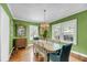Dining room with hardwood floors, green walls, large windows, and a unique chandelier at 27 Stocker Dr, Charleston, SC 29407