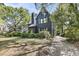 Charming exterior view of a two-story home with black siding and lush, mature landscaping at 27 Stocker Dr, Charleston, SC 29407