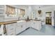 Modern kitchen features white cabinets, butcher block counters, farmhouse sink and bright blue floors at 27 Stocker Dr, Charleston, SC 29407