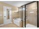 Bathroom featuring a glass enclosed shower, soaking tub with tile surround, and neutral walls at 2840 Conservancy Ln, Charleston, SC 29414