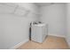 Clean laundry room with a side-by-side washer and dryer, white walls, and overhead shelving at 2840 Conservancy Ln, Charleston, SC 29414
