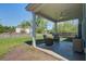 Covered back porch with outdoor seating overlooking the fenced backyard and lush greenery at 2880 Cavalcade Cir, Johns Island, SC 29455