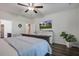 Bright bedroom featuring a mounted TV, white dresser, and a large potted plant at 2880 Cavalcade Cir, Johns Island, SC 29455