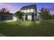 Charming two-story home features a well-manicured lawn, attached two-car garage, and inviting front porch at twilight at 2880 Cavalcade Cir, Johns Island, SC 29455