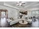 Open living area with hardwood floors, white sofa, modern lighting, and seamless flow to the kitchen at 2880 Cavalcade Cir, Johns Island, SC 29455