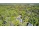 An aerial view of a charming home featuring a backyard pool surrounded by lush, mature trees at 3001 Grand Bay Ln, Johns Island, SC 29455