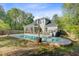 A serene backyard featuring a lovely pool, patio seating, a grill, and lush greenery all around at 3001 Grand Bay Ln, Johns Island, SC 29455