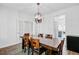 Dining room with stylish chandelier, wood table, and a view to the kitchen at 3001 Grand Bay Ln, Johns Island, SC 29455