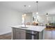Kitchen island with sink, dishwasher, and modern faucet extends into an open-concept living area at 3001 Grand Bay Ln, Johns Island, SC 29455