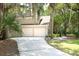 Charming home exterior with a two-car garage and a long driveway, surrounded by lush greenery at 3023 Maritime Forest Dr, Johns Island, SC 29455