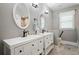 Bathroom with double vanities, decorative mirrors, and modern fixtures at 3023 Maritime Forest Dr, Johns Island, SC 29455