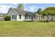 This home features a trampoline, expansive yard, bright siding, solar panels, and a porch with rocking chairs at 318 Seneca River Dr, Summerville, SC 29485