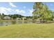 Scenic view of pond, grassy lawn, and neighborhood landscape with trees at 318 Seneca River Dr, Summerville, SC 29485