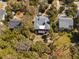 An aerial view of the backyard with a patio and yard, surrounded by trees and lush greenery at 3308 Myrtle St, Edisto Beach, SC 29438