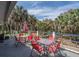 Outdoor deck with tables, chairs, and palm trees providing a relaxing space to enjoy nature at 3308 Myrtle St, Edisto Beach, SC 29438