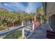 Outdoor deck with tables, chairs, and palm trees providing a relaxing space to enjoy nature at 3308 Myrtle St, Edisto Beach, SC 29438