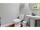 Cozy powder room with pedestal sink, round mirror and decorative shelving at 3374 Dunwick Dr, Johns Island, SC 29455