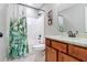 Well-lit bathroom featuring a shower-tub combo with a stylish green leaf shower curtain at 3374 Dunwick Dr, Johns Island, SC 29455