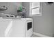 Bright laundry room with modern white washer and dryer and storage shelving at 3374 Dunwick Dr, Johns Island, SC 29455