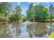 Scenic pond view with a fountain surrounded by lush trees and neighborhood homes at 339 Clayton Dr, Charleston, SC 29414