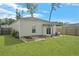 The backyard has a covered patio with modern furniture, surrounded by lush greenery and garden beds at 341 Matuskovic Dr, Charleston, SC 29414