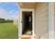 Inviting home entryway features an open door, wood floors, and view of the green backyard at 341 Matuskovic Dr, Charleston, SC 29414