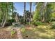 Well-maintained backyard featuring mature trees, manicured lawn, patio set, and brick pathway at 347 Prestwick Ct, Summerville, SC 29483