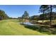 Golf course view featuring lush green grass, pond, trees and sand trap at 347 Prestwick Ct, Summerville, SC 29483