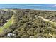 Aerial view highlighting a wooded property near a golf course and the ocean with sandy beaches in the background at 3510 Deer Run Rd, Seabrook Island, SC 29455