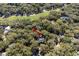 Aerial view of home nestled among mature trees in a wooded, scenic neighborhood with golf course in the distance at 3510 Deer Run Rd, Seabrook Island, SC 29455