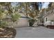 Exterior view of home with garage, with driveway and garden area, nestled in a wooded, scenic neighborhood at 3510 Deer Run Rd, Seabrook Island, SC 29455