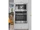 Stainless steel microwave and oven combination built into white cabinets, as seen from kitchen entrance at 3510 Deer Run Rd, Seabrook Island, SC 29455