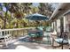 Relaxing outdoor deck area featuring a dining set, rocking chairs, and views of lush greenery at 3510 Deer Run Rd, Seabrook Island, SC 29455