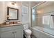 Well-lit bathroom featuring granite countertop vanity and glass enclosed tub and shower at 37 Marsh Edge, Kiawah Island, SC 29455