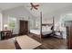 Bedroom featuring wood floors, ceiling fan, a large four-poster bed and a desk at 37 Marsh Edge, Kiawah Island, SC 29455