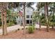 Inviting two-story home with mature landscaping, a driveway, and an American flag at 37 Marsh Edge, Kiawah Island, SC 29455