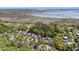 Aerial view of a neighborhood nestled among mature trees and landscaping, with waterway in background at 3717 Tip Ln, Mount Pleasant, SC 29466