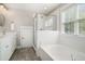 Bright bathroom featuring a glass shower, white subway tile, soaking tub and a large window at 3717 Tip Ln, Mount Pleasant, SC 29466