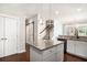 Kitchen island with granite countertop, white cabinets, and pendant lighting near a staircase and door at 3717 Tip Ln, Mount Pleasant, SC 29466