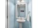 Charming powder room featuring a pedestal sink, decorative mirror, and light blue walls at 3717 Tip Ln, Mount Pleasant, SC 29466