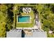 Aerial view of a backyard featuring a pool, fire pit, and deck, all surrounded by lush greenery at 409 W Indian Ave, Folly Beach, SC 29439